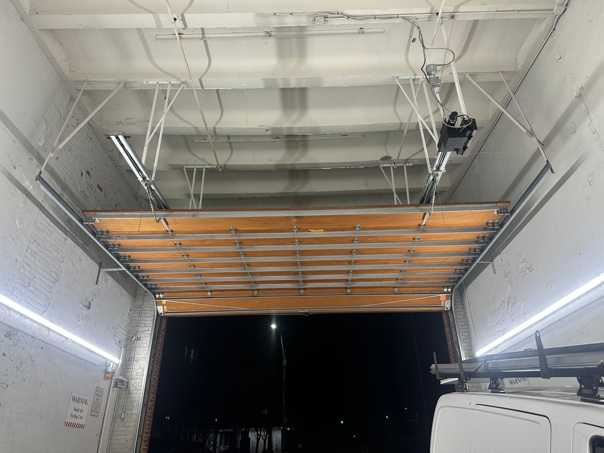 Commercial overhead door interior showing track and opener system — Massachusetts business